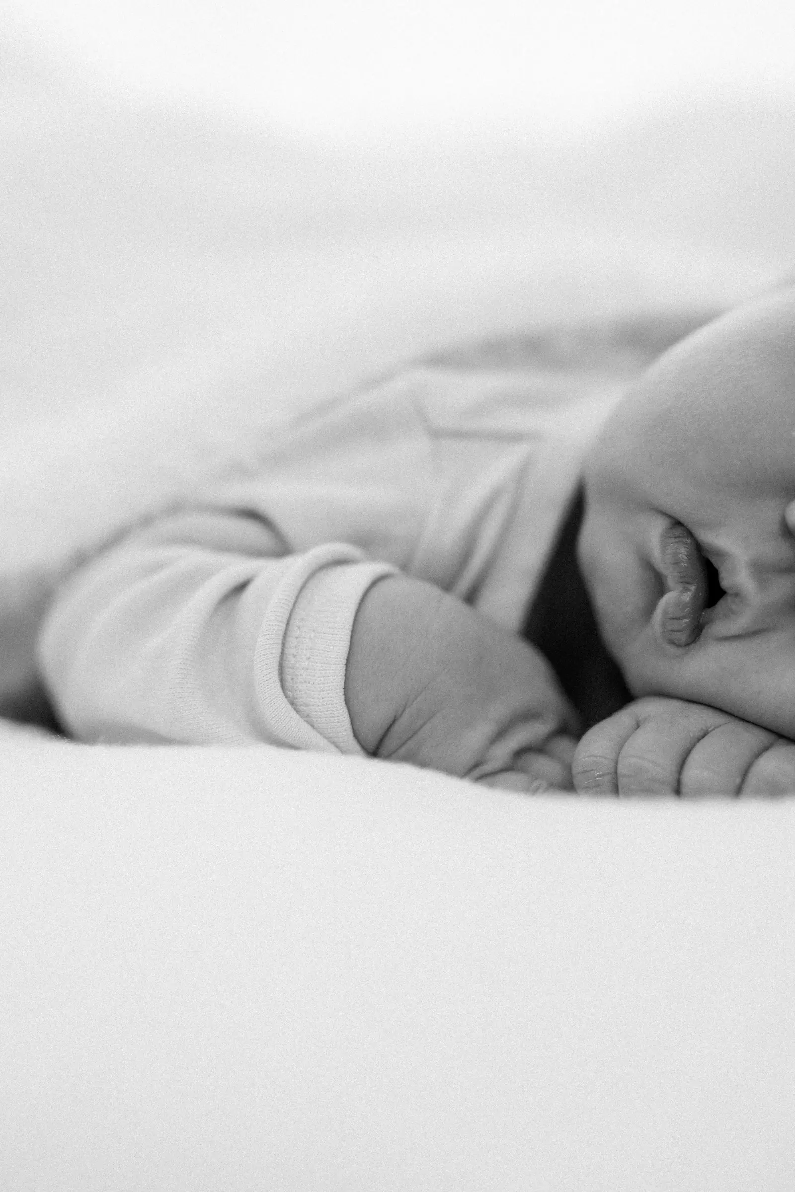 Schwarz-weiß-Detail: kleine Füße unter einer Decke